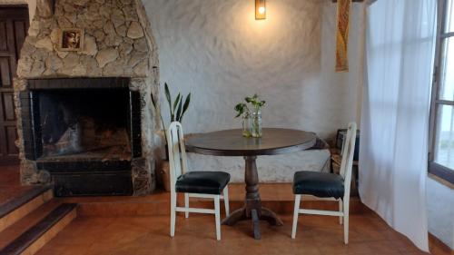 a table and chairs in a room with a fireplace at Casa Bereber in Santa Clara del Mar