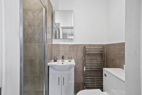a bathroom with a sink and a toilet and a mirror at Glamorous Studio for 2 people - Maidstone Town Centre - f2 BridgeCity in Kent