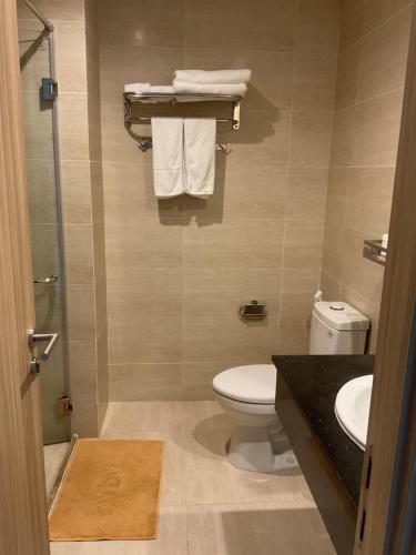 a bathroom with a toilet and a sink and towels at Green Inn Phu Quoc Hotel in Phu Quoc