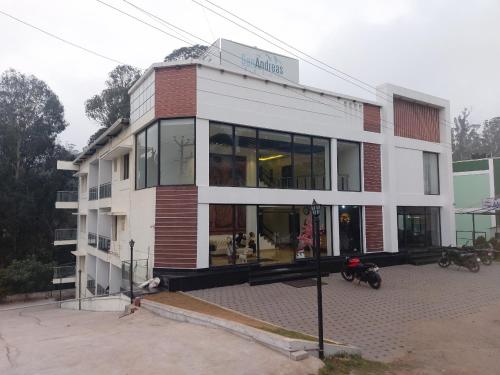 a building with a motorcycle parked in front of it at SANANDREAS HOTEL Yogiroomsonline in Kodaikānāl