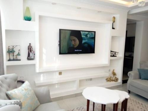 sala de estar con TV en una pared blanca en Luxurious Homes AthiRiver, en Athi River