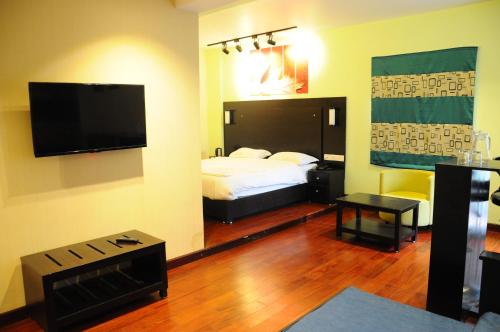 a hotel room with a bed and a flat screen tv at SANANDREAS HOTEL Yogiroomsonline in Kodaikānāl