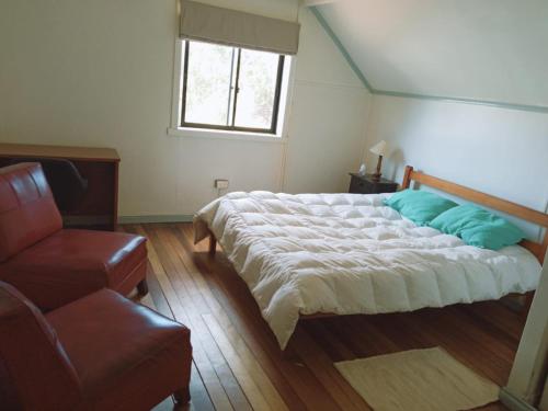 HOSTAL FERNANDO في فالديفيا: غرفة نوم بسرير كبير وأريكة
