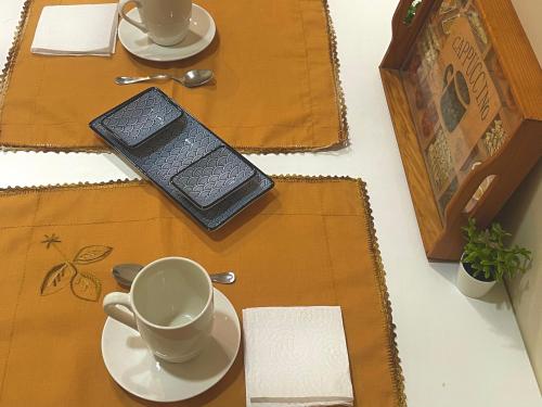 a table with two plates and a cup and saucer at Bois Argentine by ARoom VUT-LE-1079 in León