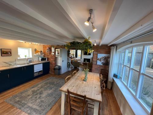 a kitchen and dining room with a table and chairs at Luxury homely open-plan Barn with log burner & games room in Wrexham