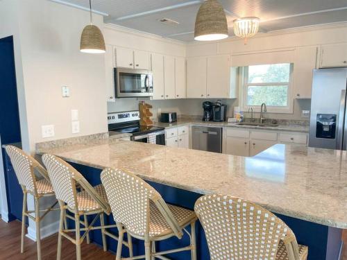 a kitchen with a large counter with chairs in it at The Gentleman Pirate in Edisto Island