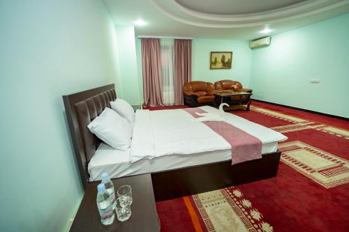 Continental New Hotel في يريفان: غرفة نوم بسرير كبير وأريكة