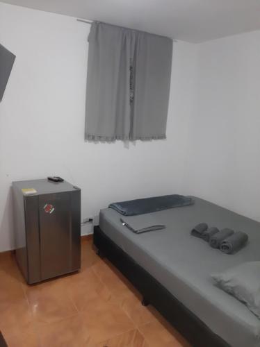 a bed in a room with a window and a table at Mundo Turismo Hostel in Medellín