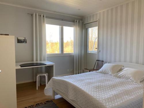 een slaapkamer met een bed, een bureau en een raam bij Pajupilli 1-10 henkilölle in Kajaani