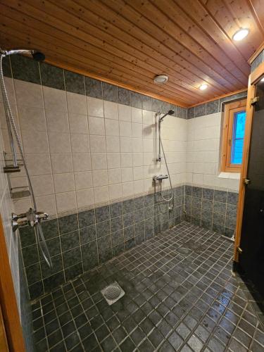 a bathroom with a shower with a tiled floor at Tahko Villa Vaarna in Tahkovuori