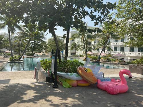 a pool with two inflatable flamingos and a swimming pool at Green Inn Phu Quoc Hotel in Phu Quoc