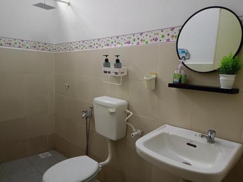 a bathroom with a toilet and a sink and a mirror at Cinoiva Homestay Gambang, Kuantan in Gambang