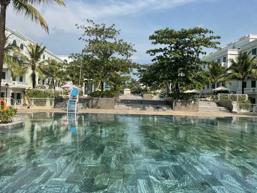 a large swimming pool with a ladder in the water at Green Inn Phu Quoc Hotel in Phu Quoc