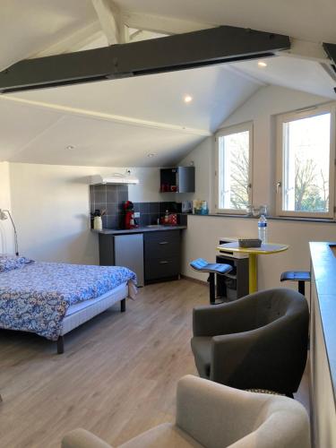 1 dormitorio con cama, mesa y cocina en Studio Cosy, en Cognac