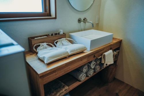 a bathroom with a sink and towels on a counter at 石打丸山スキー場徒歩30秒一棟まるまる貸切フルリノベーションのお宿 in Seki