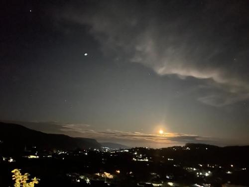 a view of a city at night with the moon at Cabin 7000 feet Nuwaraeliya in Nuwara Eliya