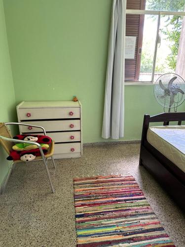 a bedroom with a bed and a dresser and a chair at Leohome in Melo
