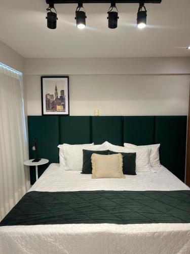 a bedroom with a large bed with a green headboard at American Flat in São Luís