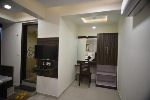 a hotel room with a desk and a television at Hotel Royal Residency in Vadodara