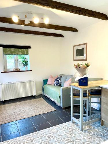 a living room with a couch and a table at The Cowshed - Cottage in Cornwall in Jacobstow