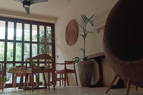uma sala de jantar com uma mesa e cadeiras e um vaso de plantas em Unique Design Apartment in La Veleta em Tulum