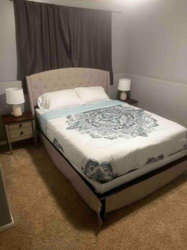 1 dormitorio con 1 cama con 2 mesitas de noche y 2 lámparas en Charming Retreat with Modern Comforts en West Fargo