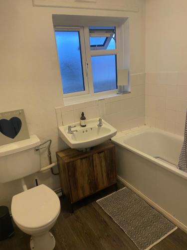 a bathroom with a toilet and a sink and a tub at 11 Lygon Walk 