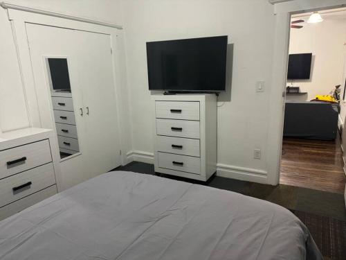 1 dormitorio con 1 cama y TV de pantalla plana en NYC Gateway: Cozy Home with Easy Access, en Passaic