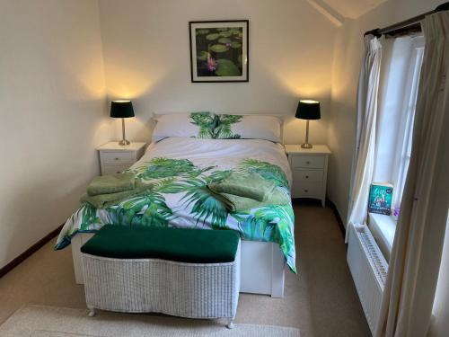 a bedroom with a bed with a green blanket and a chair at Nutshell in Sturminster Newton