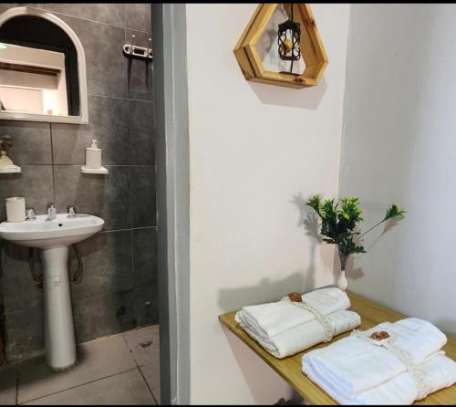 uma casa de banho com lavatório, espelho e toalhas em DEPARTAMENTO Mendoza em Las Heras