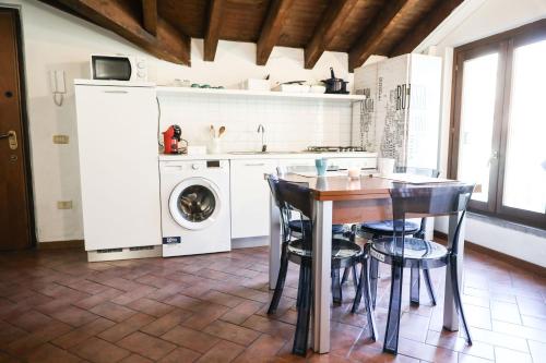 a kitchen with a table and chairs and a washing machine at Piccinardi house - appartamento 4 posti letto in Crema