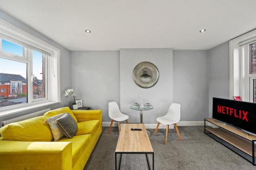 a living room with a yellow couch and a table at BridgeCity Modern Holiday Condo in Maidstone - f8 in Kent