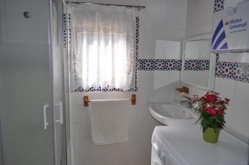 y baño blanco con lavabo y ducha. en Cortijo Rural Las Nogueras, en Cortijada Los Chorreros