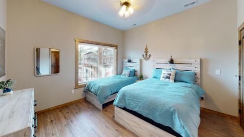a bedroom with two twin beds and a mirror at Table Rock Lake Luxury Resort Lodge - Boat Slip in Branson