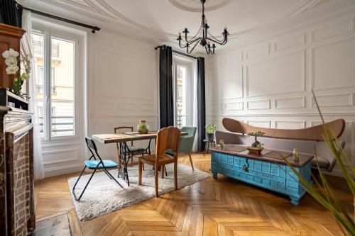 een woonkamer met een tafel en een bank bij Au marche aux puces de saint ouen in Saint-Ouen