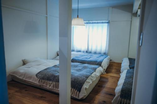 a bedroom with a bed and a window at 石打丸山スキー場から徒歩30秒フルリノベの一棟貸切お宿 in Seki
