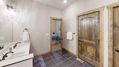 a bathroom with a sink and a wooden door at Luxury Lake Resort Lodge in Branson