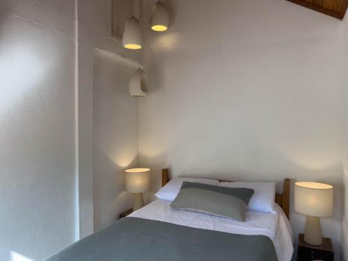 a bedroom with a bed with two lamps on it at Pousada Vagalume in Tiradentes