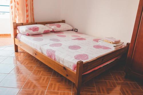 un dormitorio con una cama con rosas rosas. en Room with amazing sea view en Himare