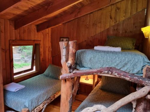 a bedroom with two beds in a log cabin at casa del Leñador Huilo Huilo in Puerto Fuy