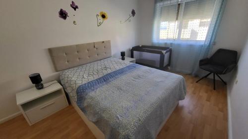 1 dormitorio con 1 cama, 1 silla y 1 ventana en Sol e Mar, en Esmoriz