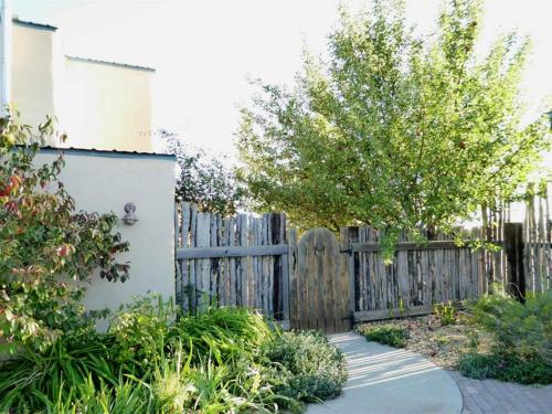 a fence with a wooden gate in a yard at Taos Mountain Views- Cozy Home-Special Rates in El Prado