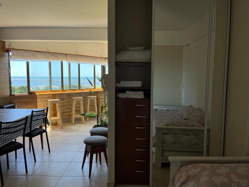 1 dormitorio con 1 cama y comedor con mesa en Departamento excelente vista al mar frente al golf (Alem) en Mar del Plata