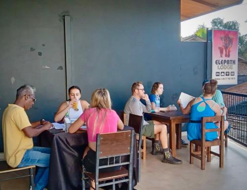 un groupe de personnes assises à table dans un restaurant dans l'établissement Elepath Lodge- Pinnawala, à Pinnawala