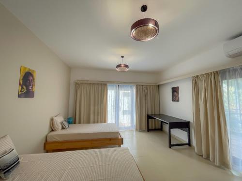 a bedroom with two beds and a desk in it at Villa Blanca Dahab in Dahab