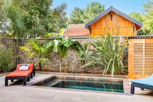une piscine avec deux chaises et une maison dans l'établissement La Cabane du Huga N°1, à Lacanau