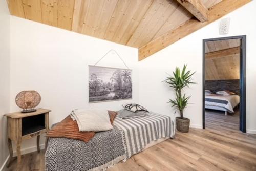 une chambre avec un lit, une table et un miroir dans l'établissement La Cabane du Huga N°1, à Lacanau