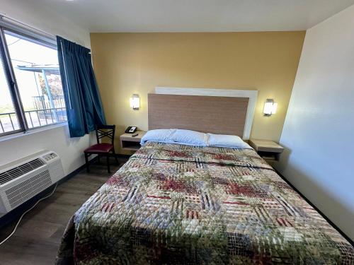 a hotel room with a bed and a window at Royal Inn and Suites Charlotte Airport in Charlotte