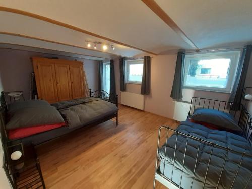 1 dormitorio con 2 camas y 2 ventanas en FEWO 1a, en Waltenhausen