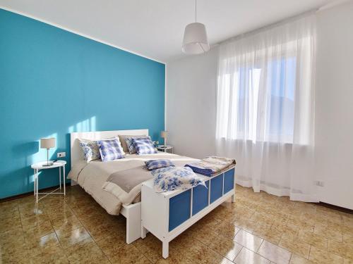 a blue bedroom with a bed and a blue wall at Panoramic lakeview house Bellagio in Civenna